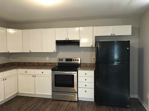 a kitchen with black appliances and white cabinets