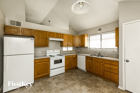 a kitchen with white appliances and wooden cabinets