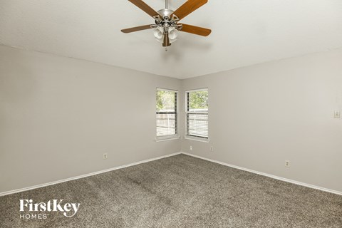 the living room has a ceiling fan and carpet