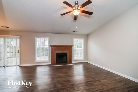 a living room with a fireplace and a ceiling fan