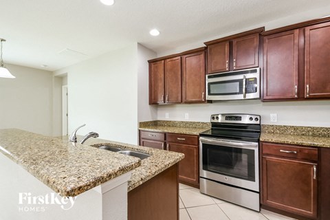 a kitchen with granite counter tops and wooden cabinets