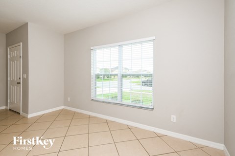 a living room with a large window and a tiled floor