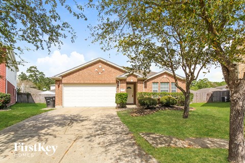 a brick house with a white garage door and a driveway