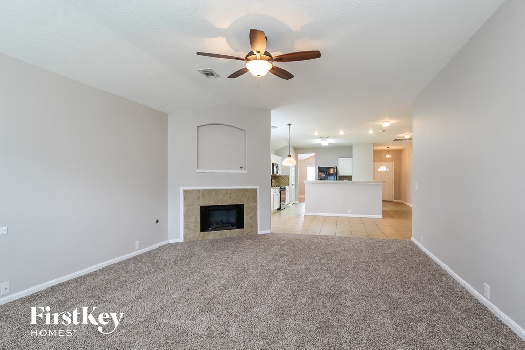 a living room with a fireplace and a ceiling fan