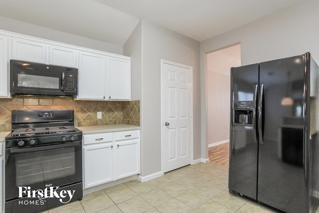 a kitchen with stainless steel appliances and white cabinets