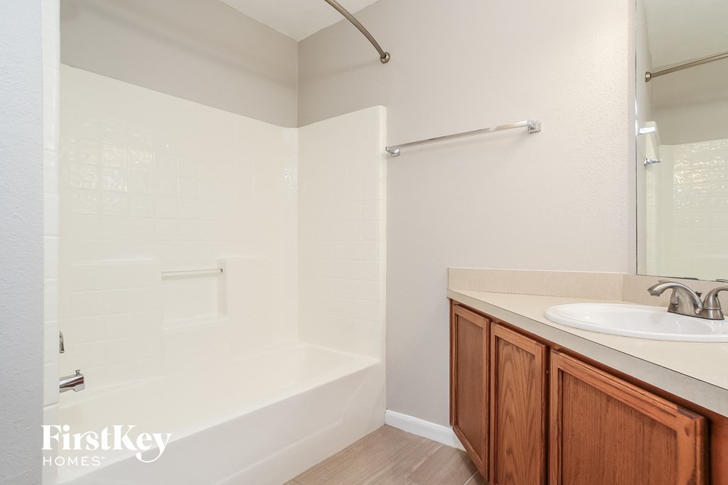 a bathroom with a tub and a sink and a mirror