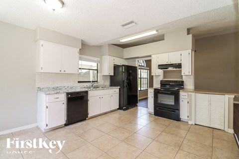 a kitchen with white cabinets and black appliances