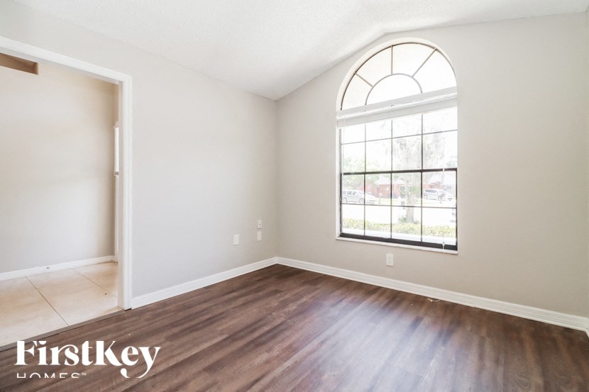 a living room with hardwood floors and a large window