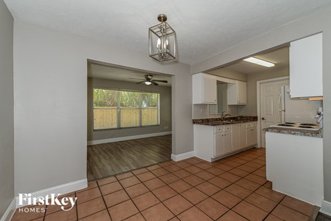 A kitchen with white cabinets and a tile floor.