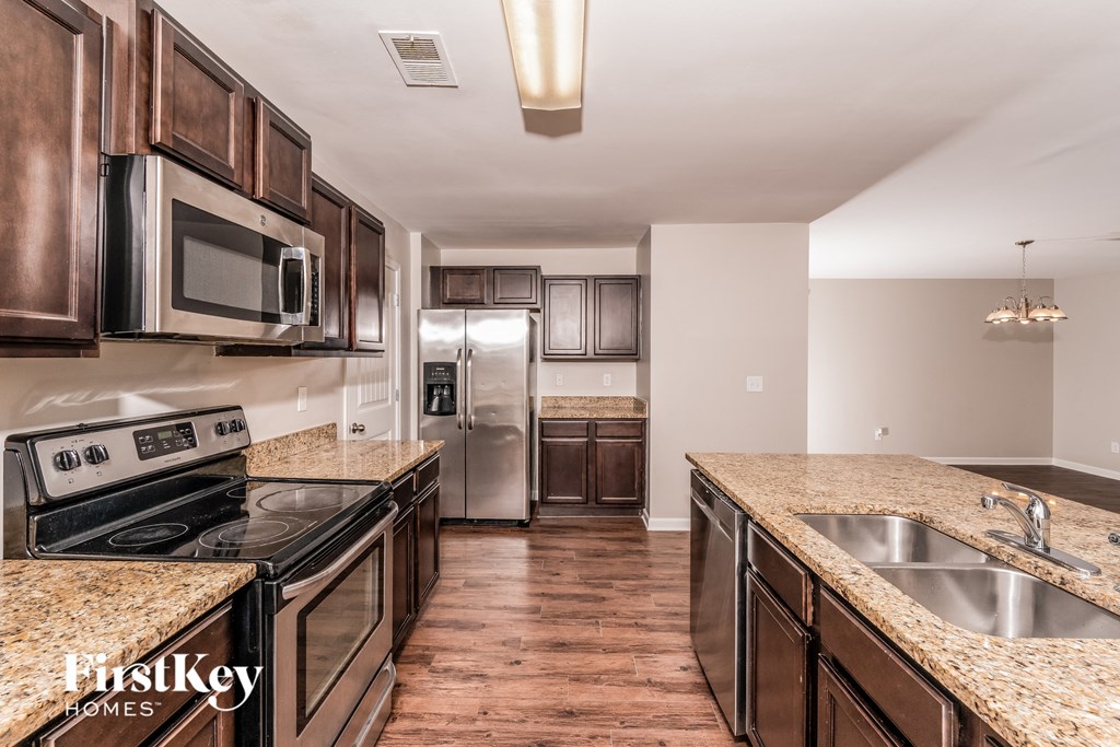 A kitchen with brown cabinets and a granite countertop.