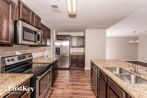 A kitchen with brown cabinets and a granite countertop.