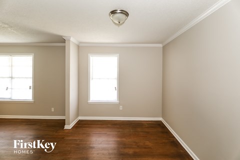 A room with wooden floors and two windows.