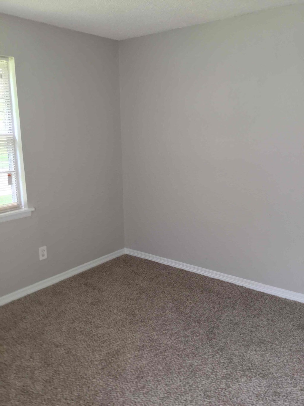 an empty room with white walls and a window