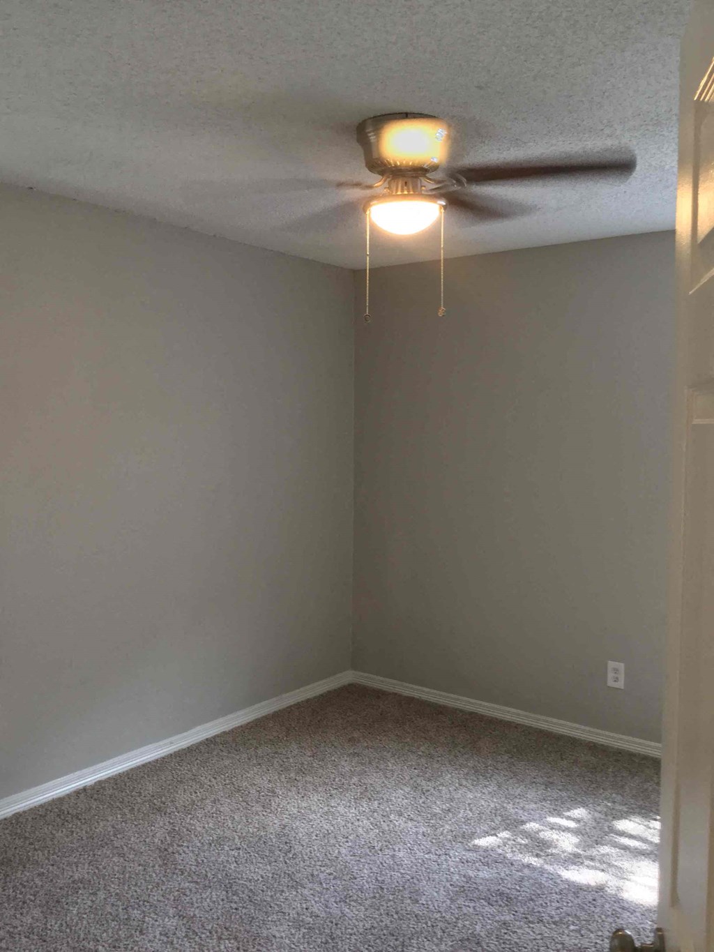 a empty room with a ceiling fan and a light
