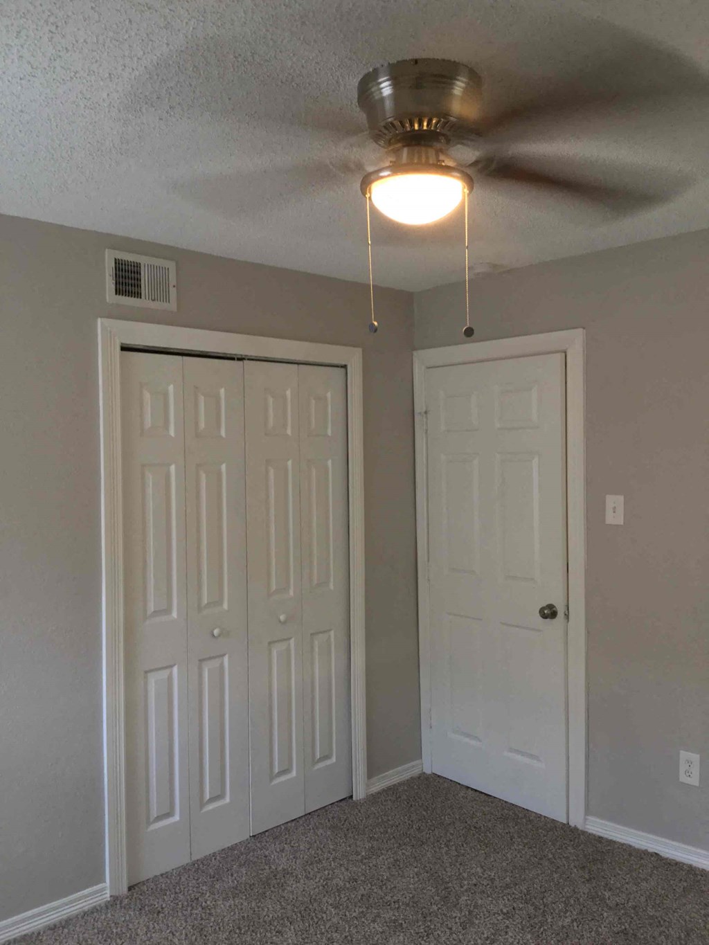 a bedroom with a ceiling fan and a closet