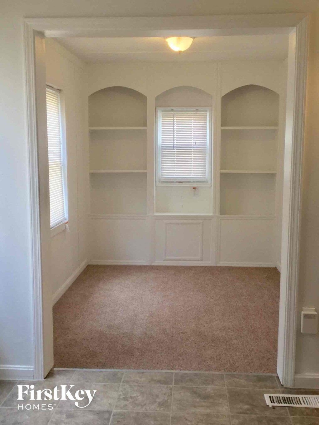A room with arched windows and shelves.