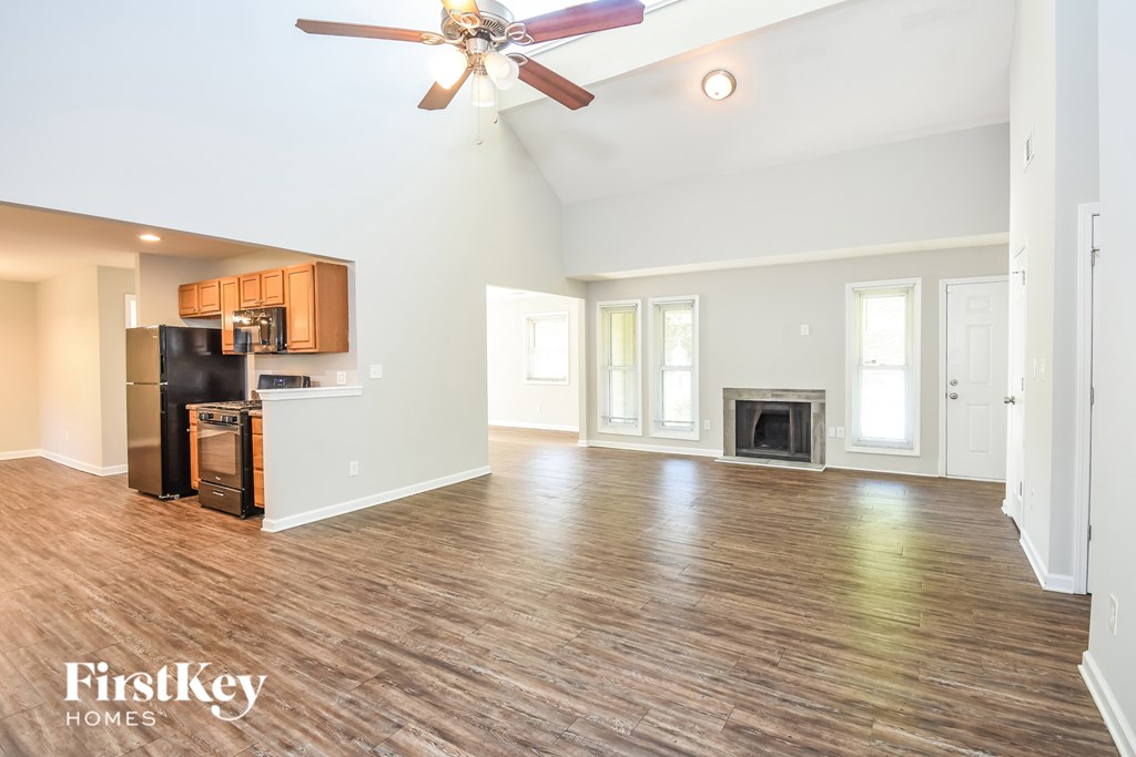 A spacious living room with wood flooring and a fireplace.