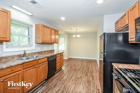 A kitchen with wooden cabinets and a black fridge.