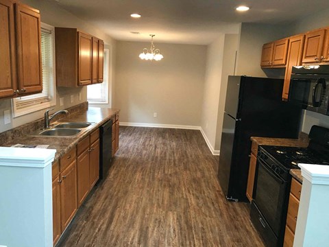 A kitchen with wooden cabinets and black appliances.