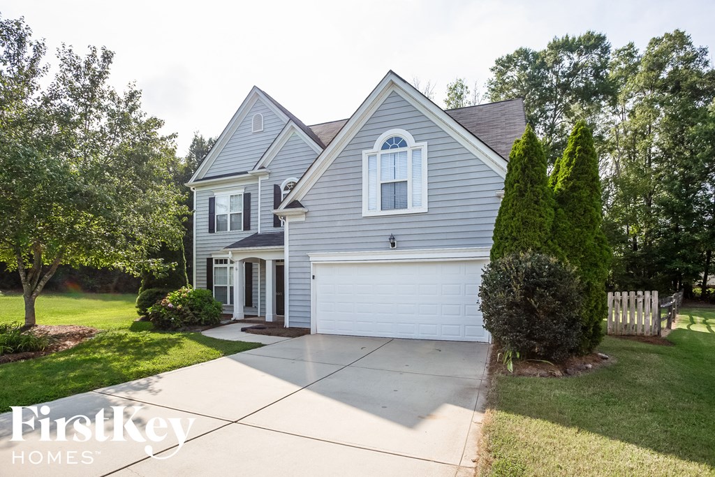 A house with a grey roof and a white garage door.