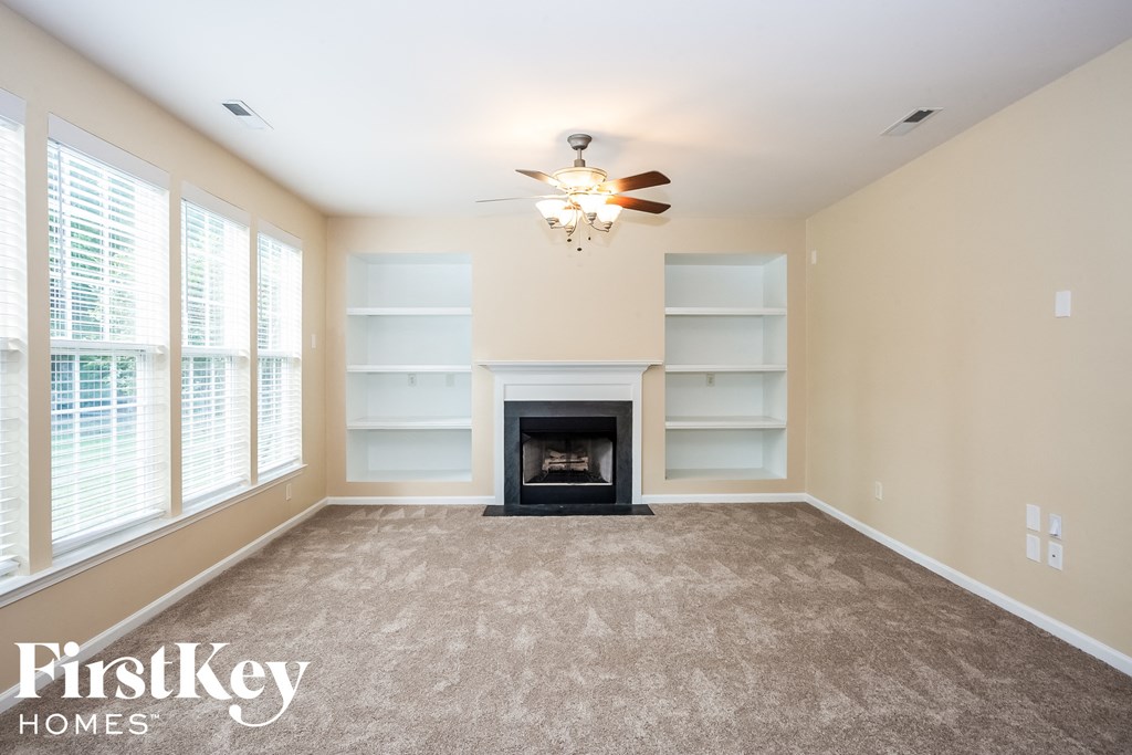 A well-lit living room with a fireplace and a chandelier.