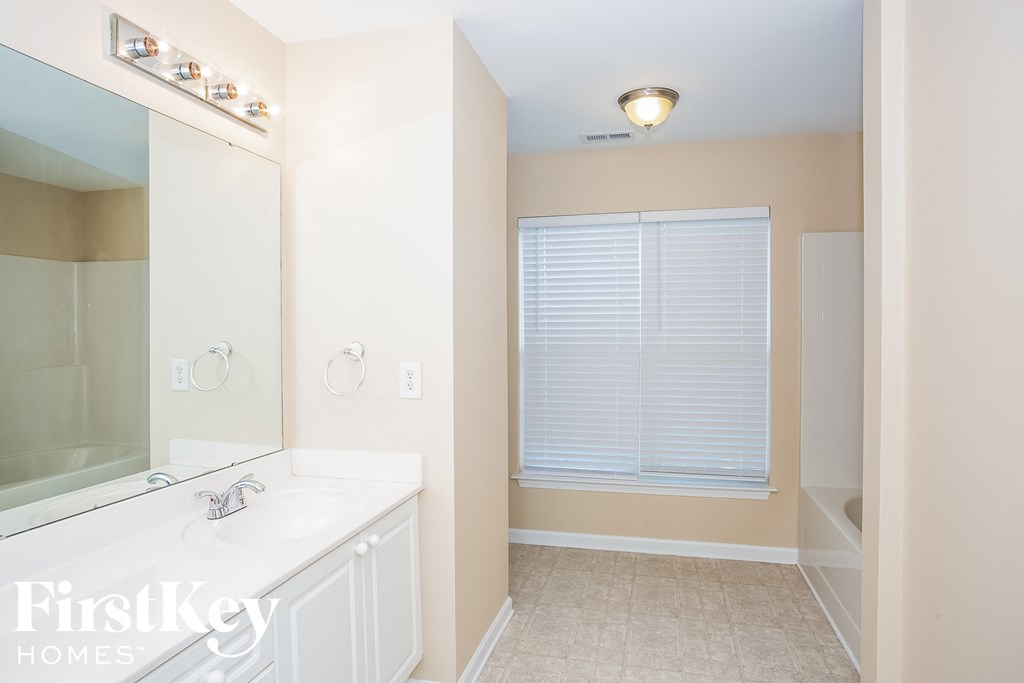 A bathroom with a white sink and a mirror.