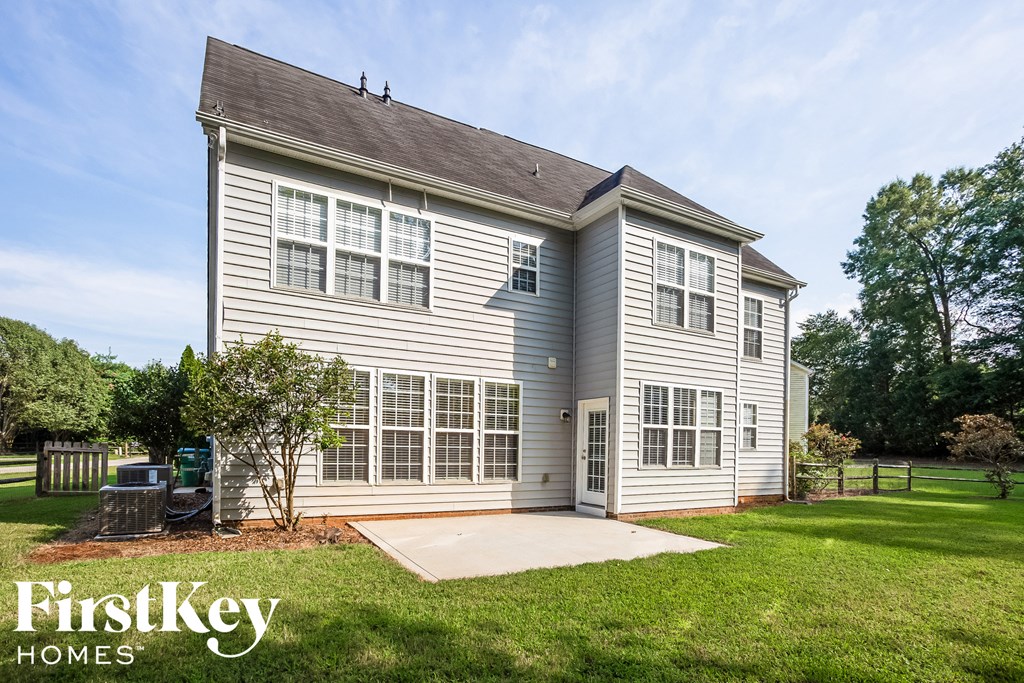 A house with a grey and white exterior and a brown roof.