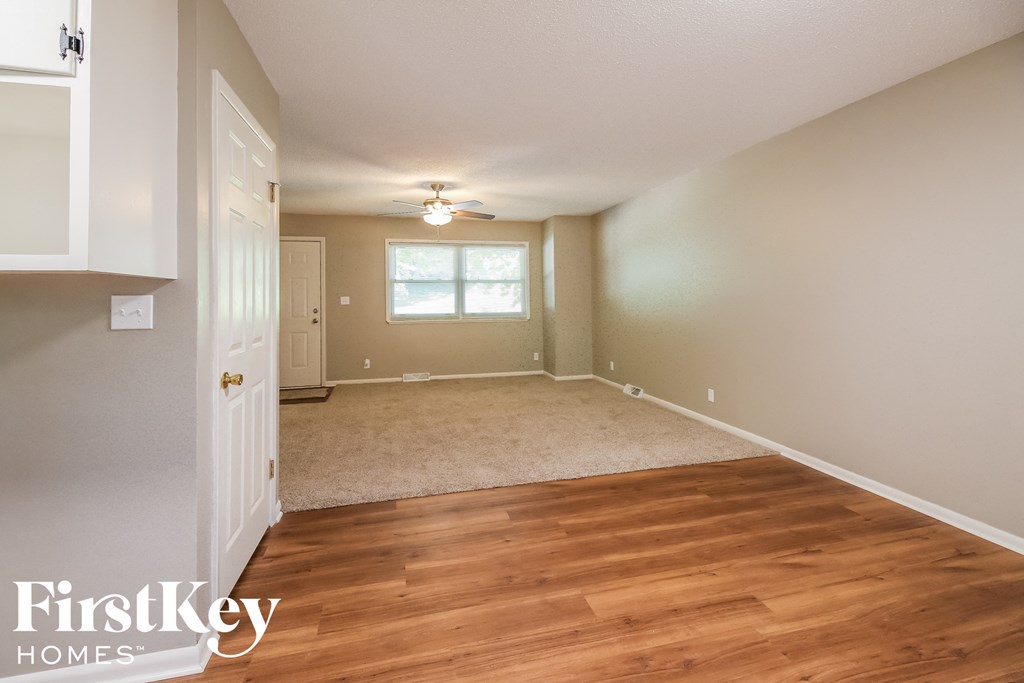 an empty living room with wood flooring and a white door