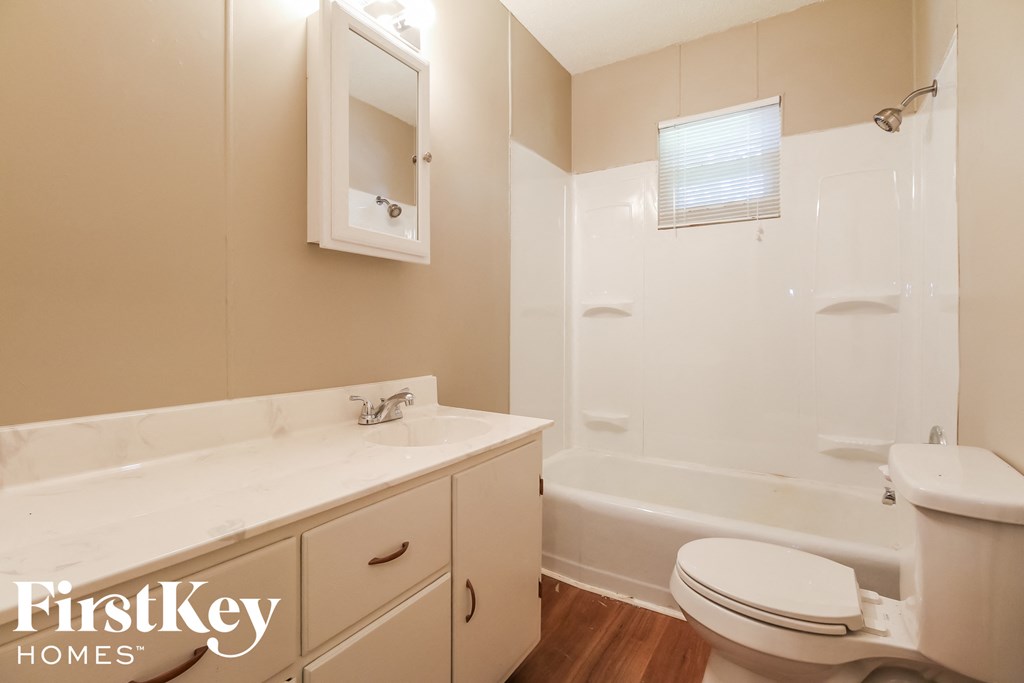 a bathroom with a toilet and a tub and a sink