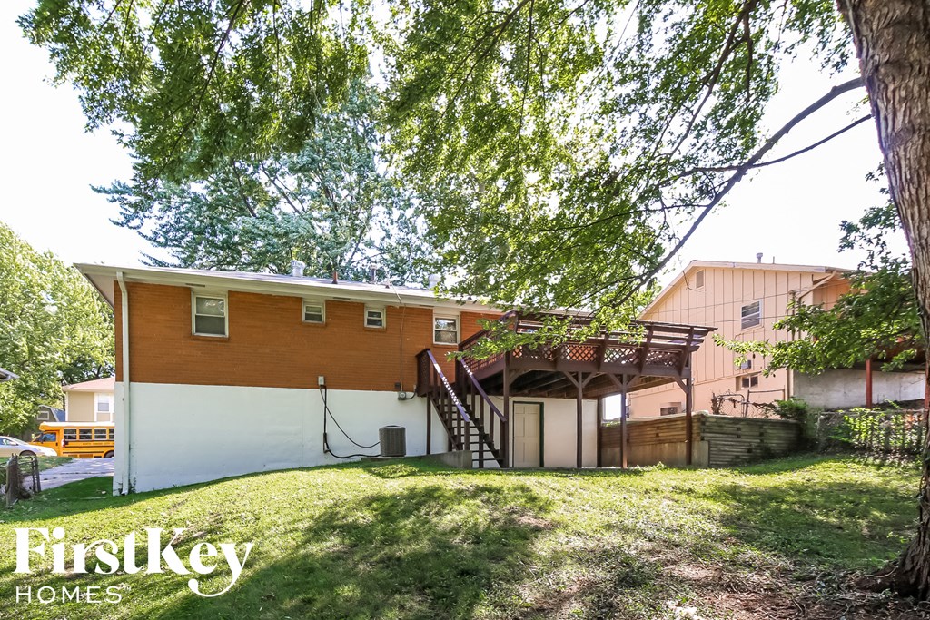a house with a deck and a tree in the yard