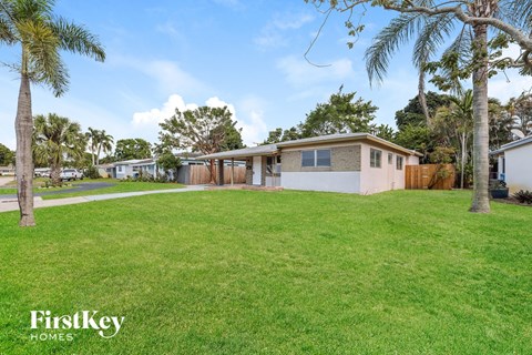 a house with a yard and palm trees
