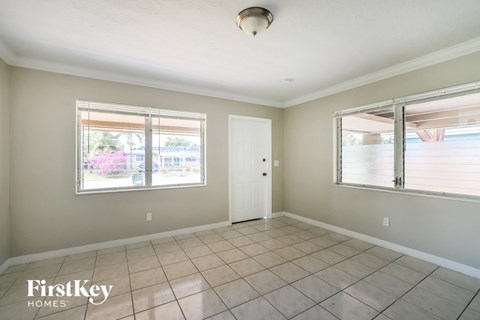 an empty living room with two windows and a door