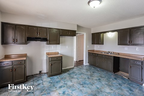 a kitchen with dark cabinets and a sink and a counter top