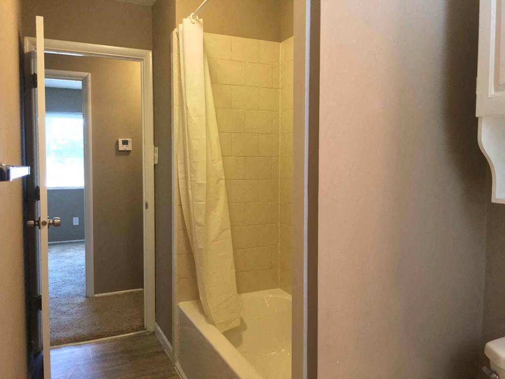 A bathroom with a white shower curtain.