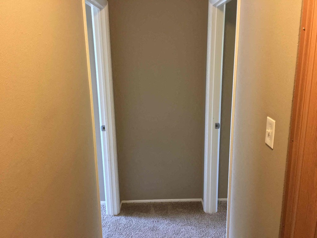 A white door is in a room with a carpet floor.