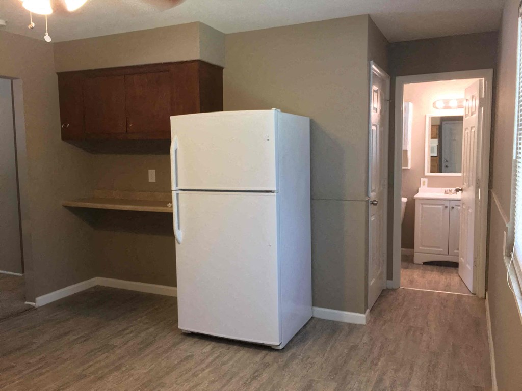 A white refrigerator in a room with brown cabinets.
