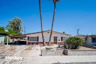a small house with two palm trees in front of it