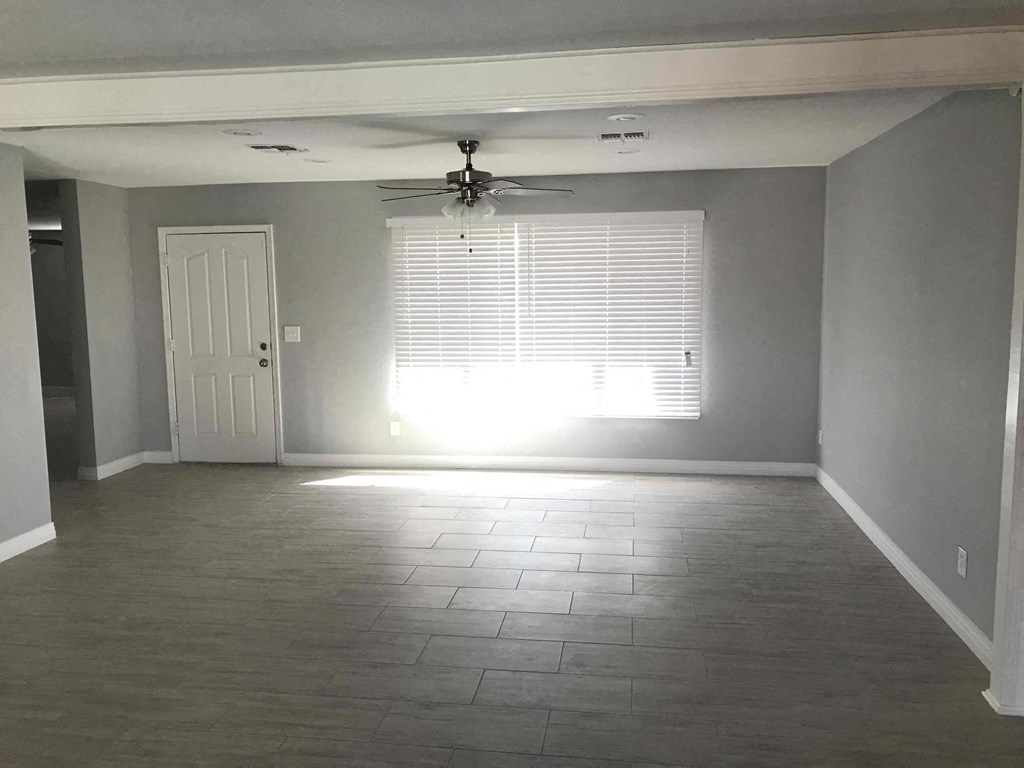 A room with a ceiling fan and a door.