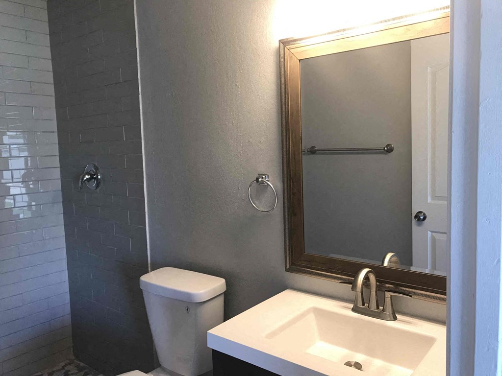 A white toilet sits next to a white sink in a bathroom.