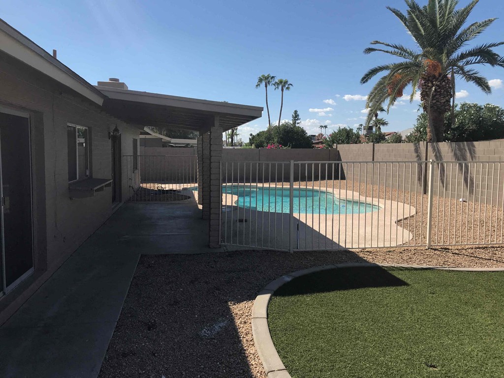 A house with a pool and a fence.