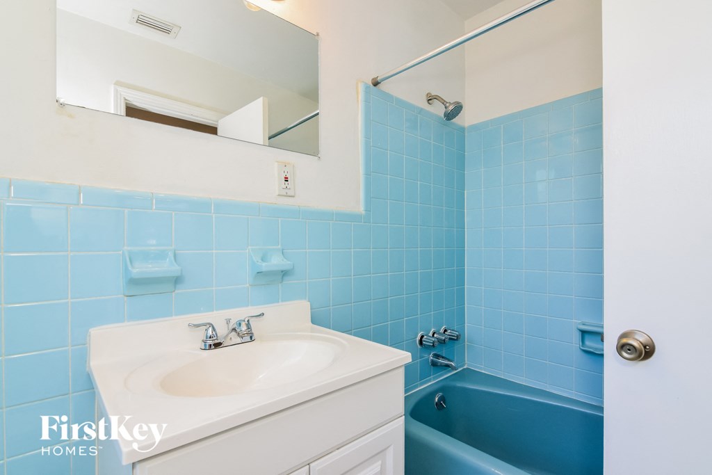 a blue and white bathroom with a sink and a tub