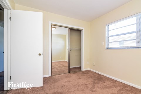 a bedroom with a closet and a window and a door to a closet