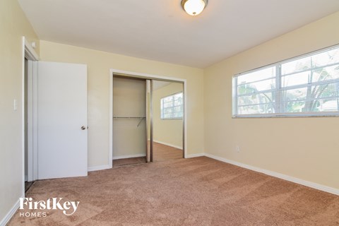 a bedroom with a closet and a large window