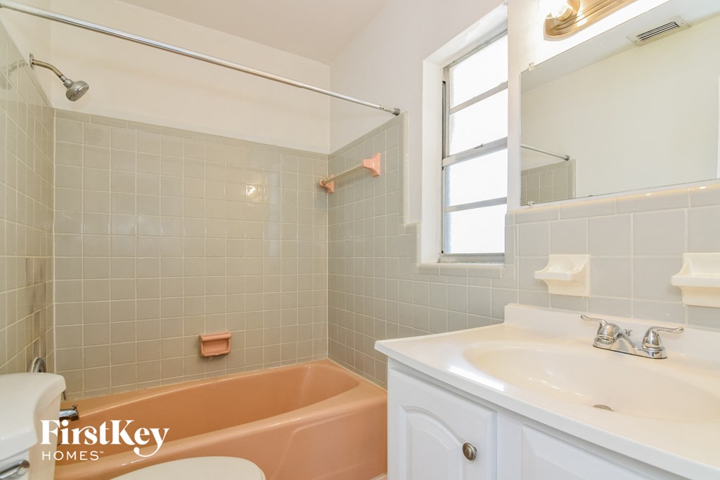 a bathroom with a tub and a sink and a window