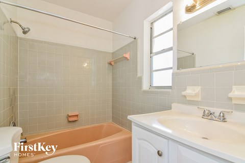 a bathroom with a tub and a sink and a window