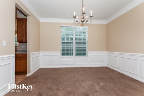 a dining room with a chandelier and a window