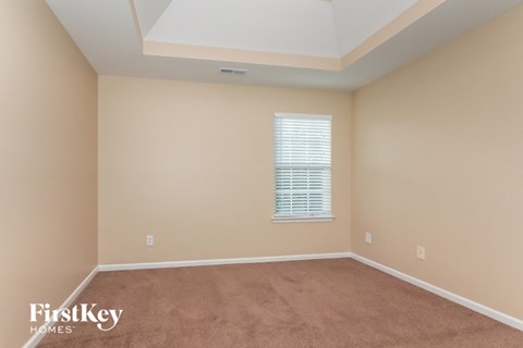 a bedroom with a carpeted floor and a window