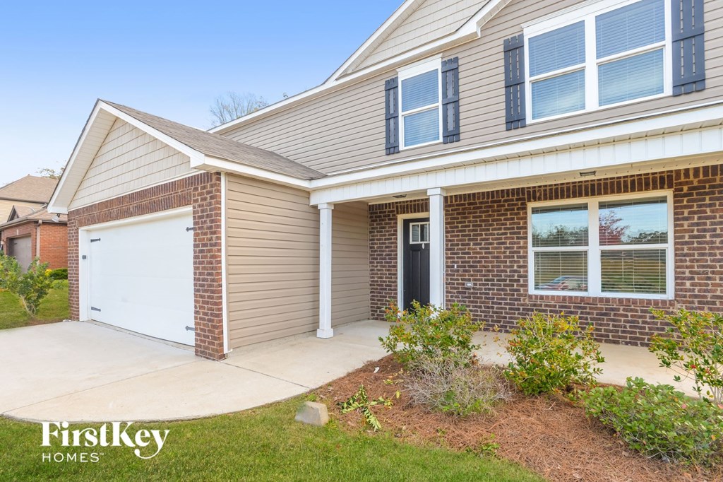 the front of a house with a white garage door