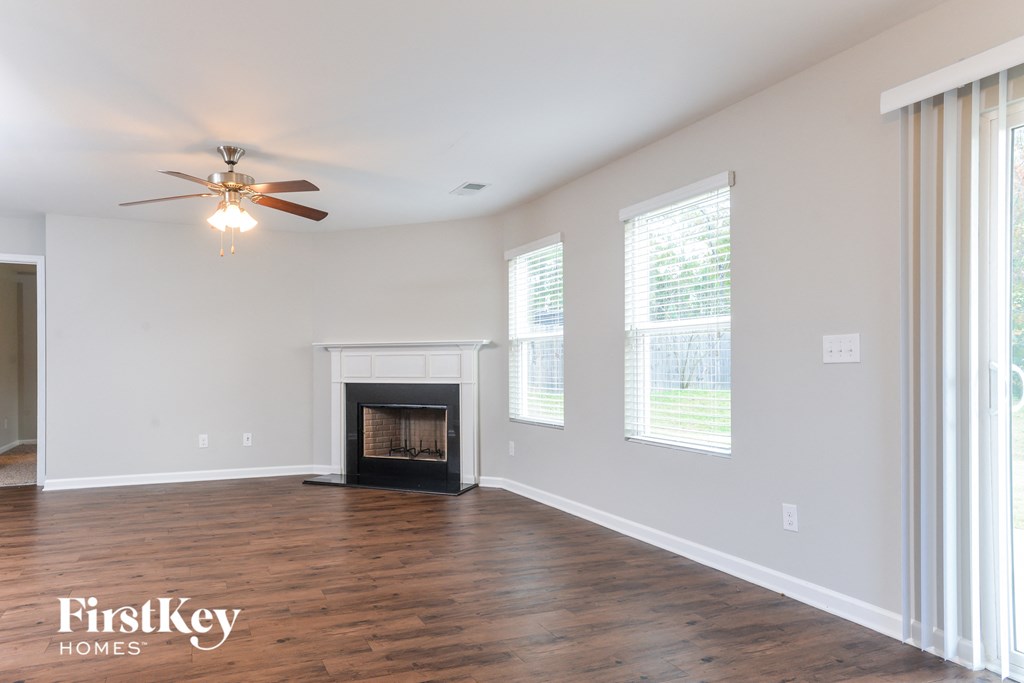 a living room with a fireplace and a ceiling fan