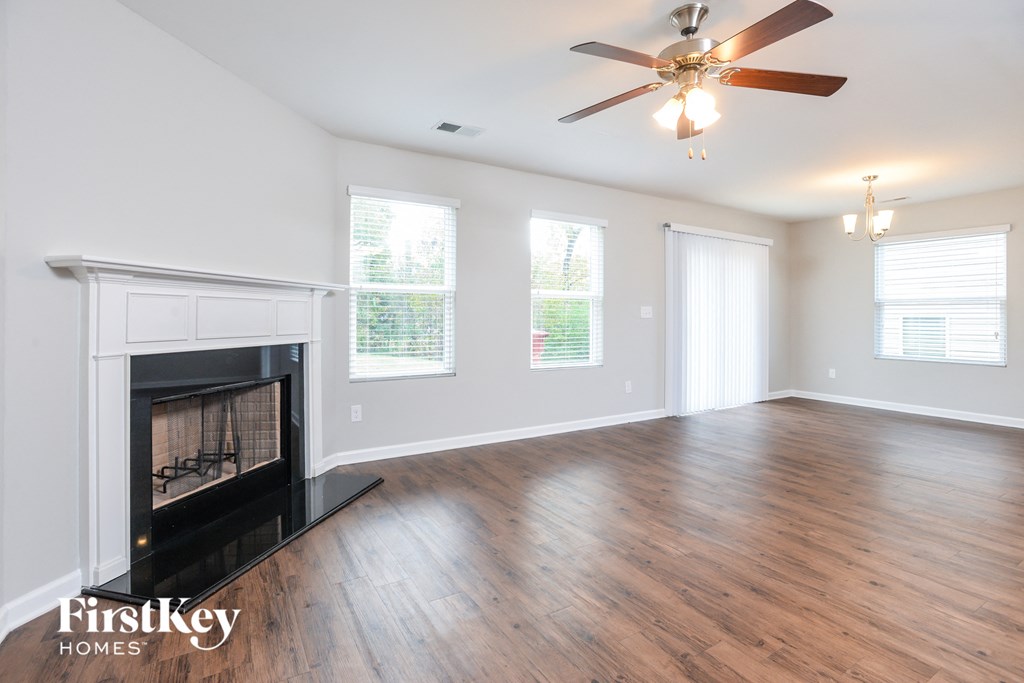 a living room with a fireplace and a ceiling fan